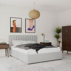 a white bed sitting in a bedroom next to two pictures on the wall above it