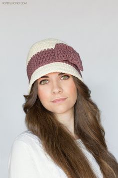 a woman with long brown hair wearing a white and burgundy crochet beanie