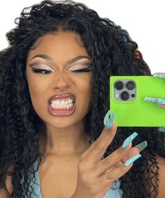 a woman taking a selfie with her cell phone in front of her face while wearing blue and green nail polish