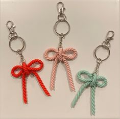 three different colored key chains with bows on them