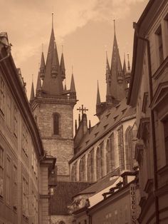 an old city street with tall buildings and steeples