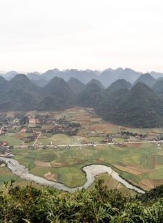 an aerial view of a valley with mountains in the background