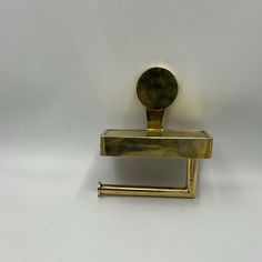 a metal object that is on top of a white surface and has a handle in the middle