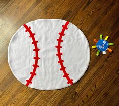 a close up of a baseball on a wooden floor near a play doughnut toy