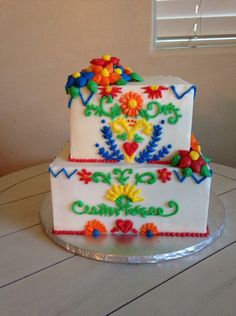 a three tiered cake decorated with colorful flowers