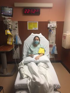 a woman in a hospital bed wearing a face mask