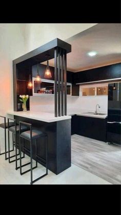 a kitchen with black cabinets and white counter tops