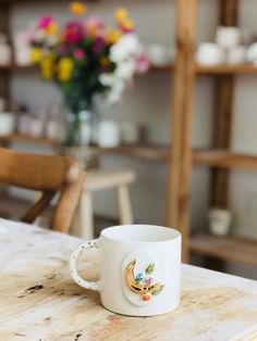 a white coffee cup sitting on top of a wooden table