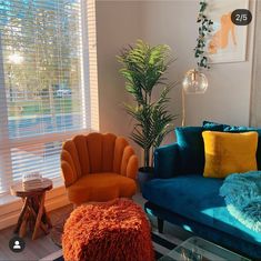 a living room filled with furniture and a large window covered in shades of blue, orange and yellow