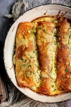 a casserole dish with cheese and herbs