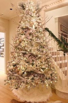 a white christmas tree with silver and gold ornaments