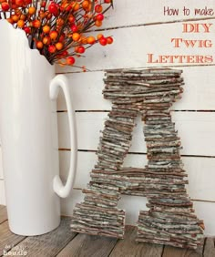 the letters are made out of newspapers next to a white vase with orange berries in it