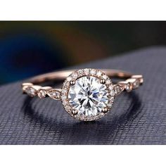 a rose cut diamond engagement ring on top of a cushioned surface with diamonds around it