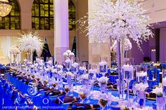 the tables are set with blue linens and centerpieces for an elegant event