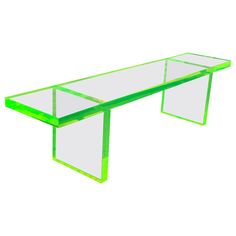 a green glass table sitting on top of a white floor next to a metal frame