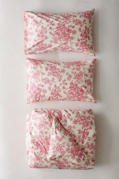 pink and white floral bedding with matching pillowcases on a white background, top view