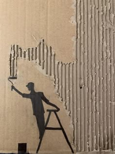 a man is painting on the side of a wall with paint rollers and a ladder