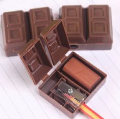 four pieces of chocolate sitting on top of a white table next to a pencil and eraser