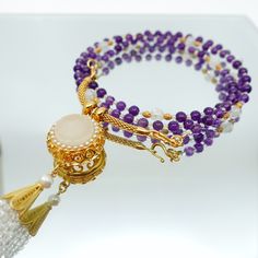 This beautiful necklace set features a multi-style beaded amethyst necklace with a white jade and zircon tassel pendant. The necklace is made up of 81 primary gemstones, with every 9 gemstones grouped and connected by spacer gemstones. The pendant can be detached from the necklace and replaced with any pendant you like, and the necklace can also be worn as a glasses chain. The ancient Chinese believed that the number 9 symbolized eternity, and that surviving 81 tribulations could help a person r Asian Jewelry, Divine Nature, Number 9, White Jade, Glasses Chain, Amethyst Necklace, Golden Globes, Ancient Chinese, Beautiful Necklace