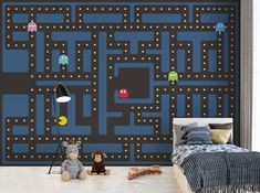 a child's bedroom decorated in blue and black with pacman wallpaper on the walls