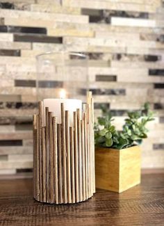 a wooden candle holder sitting on top of a table next to a potted plant