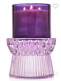 a purple glass candle holder with two lit candles