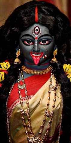 a close up of a person with makeup and jewelry on their face, wearing an elaborate headdress