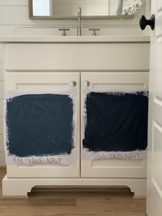 the bathroom vanity has two blue paint samples on it, and one is white with black