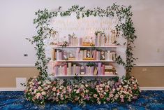 the bookshelf is decorated with flowers and greenery for a wedding or bridal party