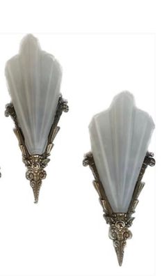 three wall sconces in the shape of art deco style with white glass shades