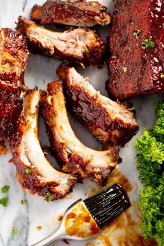 barbecue ribs and broccoli on a plate with a spatula next to them