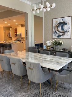 a dining room table surrounded by gray chairs