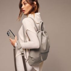 Elevate your daily routine with the Bandolier Drawstring Backpack - a perfect balance of luxury and practicality. The backpack is crafted from the finest, durable pebble leather and features an adjustable leather drawstring opening that cinches to close and open the bag. The classic and timeless silhouette of the backpack is designed to fit a 13-inch laptop, making it perfect for everyday use. Modern Gym Bag With Removable Pouch, Everyday Drawstring Shoulder Bag With Adjustable Strap, Versatile Soft Leather Travel Backpack, Functional Leather Backpack For On-the-go, Modern Gym Bag With Adjustable Strap, Versatile Gray Backpack For Daily Use, Sporty Gym Bag With Adjustable Straps For Everyday, Everyday Drawstring Backpack With Adjustable Strap, Versatile Soft Leather Backpack