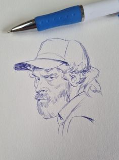 a pencil drawing of a man with a hat on his head and beard, next to a blue marker