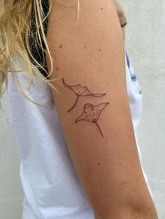 a woman's arm with a bird tattoo on the left side of her arm