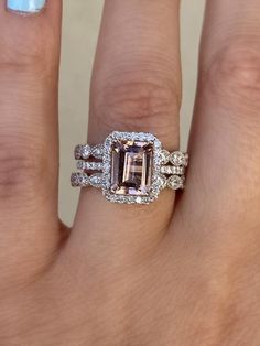 a woman's hand with two rings and an engagement ring on top of her finger