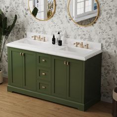 a bathroom with two sinks and mirrors on the wall next to a potted plant