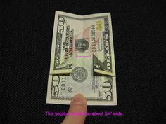 a hand holding a folded dollar bill with the words fold corners down as shown