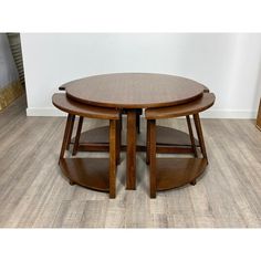 two wooden tables sitting on top of each other in front of a white wall and wood floor