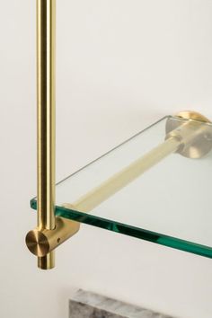 a glass shelf with a brass handle on it