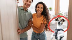 a man standing next to a woman with a dog on her back and a red circle in front of them