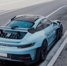 a blue sports car is parked on the side of the road