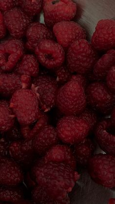 raspberries are in a metal bowl on the table