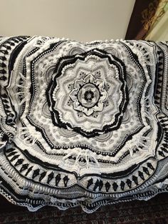 a black and white crocheted blanket sitting on top of a bed