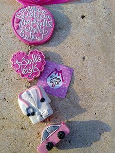 some pink and white items are laying on the ground next to each other, including a car keychain