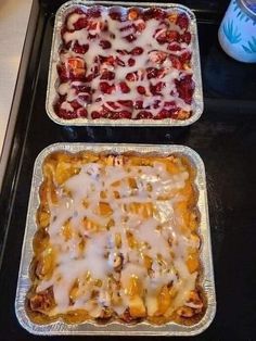 two baking pans filled with food sitting on top of a stove next to each other