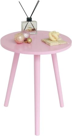 a small pink table with some decorations on it and a radio sitting on top of it