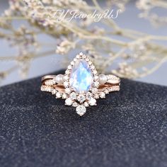 an engagement ring with a pear shaped blue topazte surrounded by diamonds