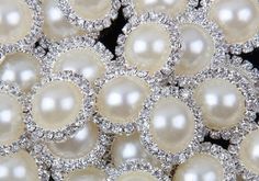 a bunch of white pearls and diamond brooches