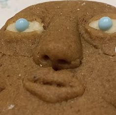 a close up of a cookie face with blue eyes